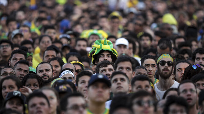 Aficionados brasileños siguen con gesto grave el partido ante Bélgica del pasado viernes.