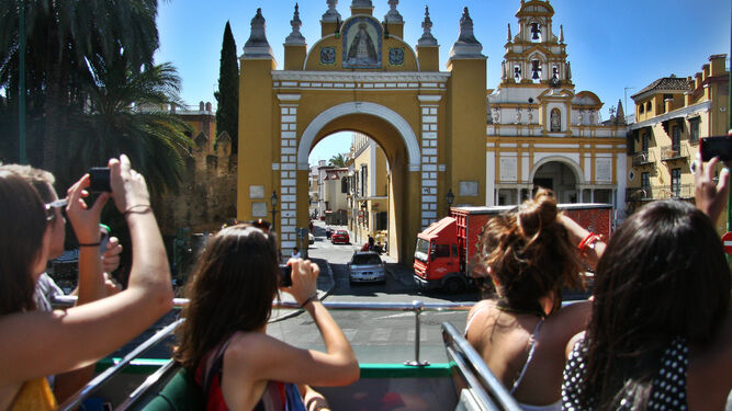 Turistas fotografían la Basílica de la Macarena desde un autobús turístico.