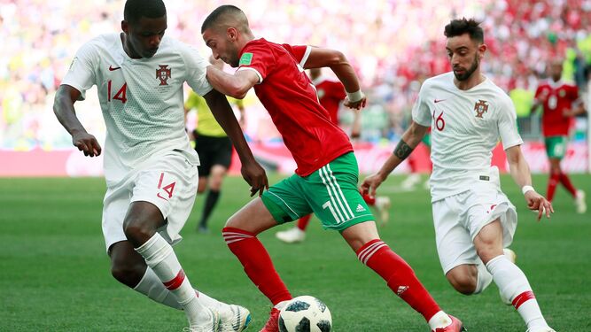 William Carvalho y su compañero en Portugal Bruno Fernandes tratan de parar el avance del marroquí Hakim Ziyech durante el Mundial de Rusia.