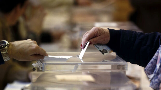 Una votante deposita su voto en una urna en unas elecciones.