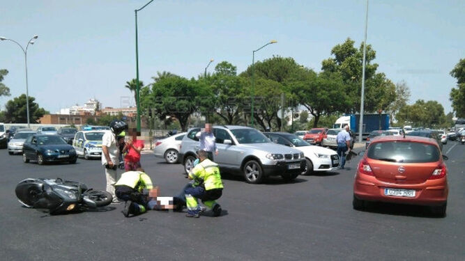 Sanitarios atienden al motorista accidentado sobre la calzada.