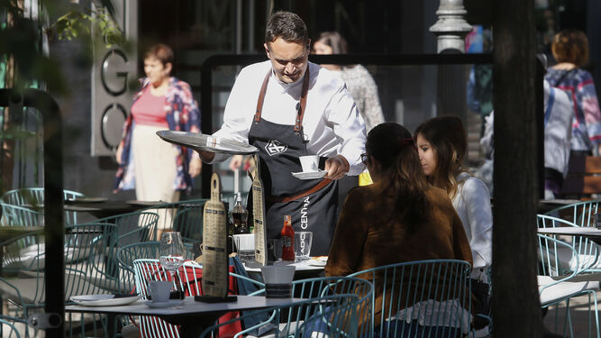 Un camarero sirve una mesa en Granada.