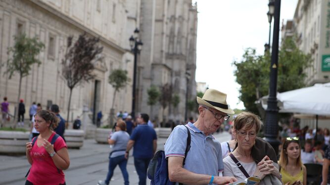 Un turista consulta un plano de Sevilla en la Avenida.