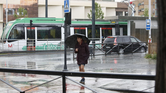Una joven se resguarda de la tormenta en Granada.