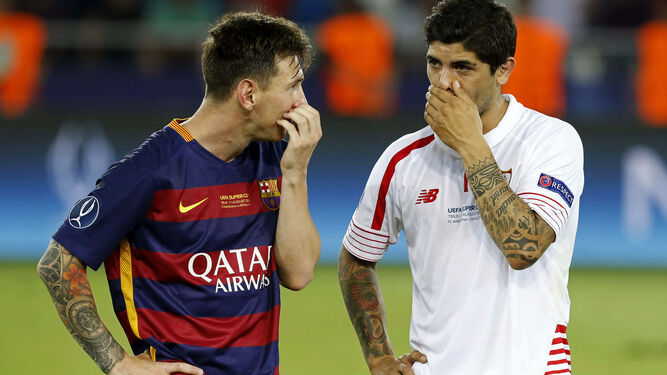 Messi y Banega, líderes de Barcelona y Sevilla, charlan durante la Supercopa de Europa en Tiflis.