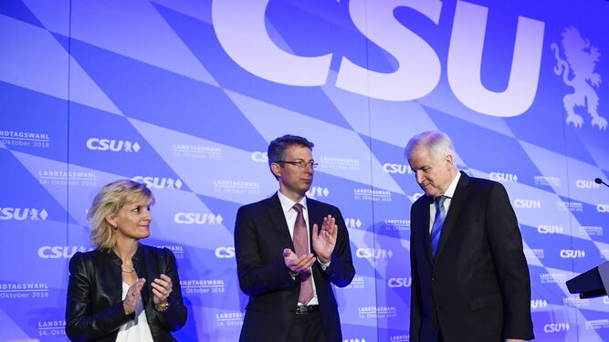 El ministro del Interior alemán, Horst Seehofer, es aplaudido por dos compañeros de la CSU en la sede de Múnich.