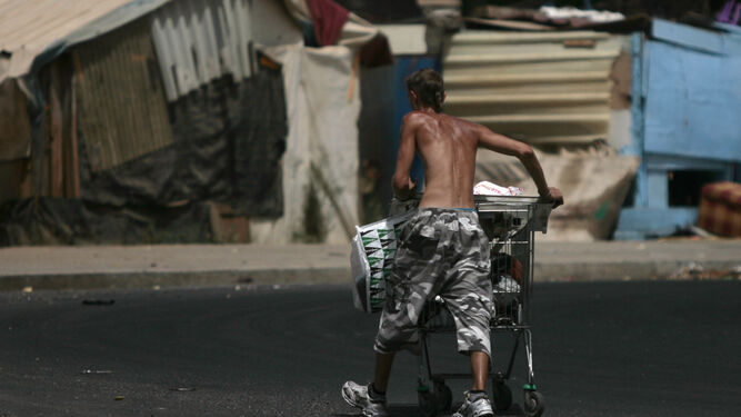 Un joven traslada chatarra en el poblado chabolista de El Vacie.