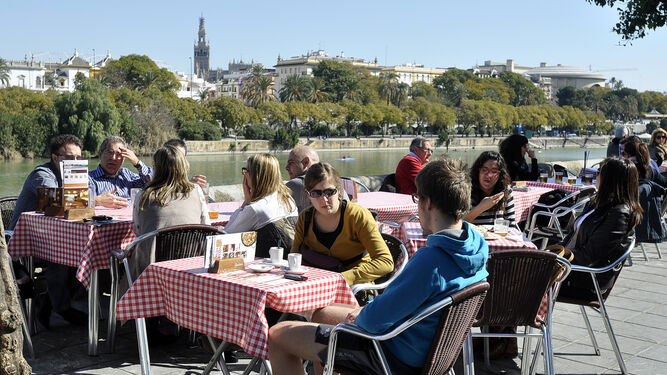 Varias personas disfrutan del buen tiempo en la terraza de un bar en Sevilla.