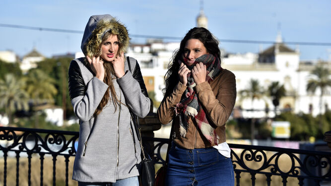 Dos jóvenes abrigadas con chaquetones y bufandas en Sevilla.