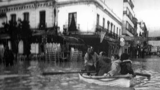 Una imagen de una familia en barca por la calle Ancha de Sanlúcar de Barrameda.