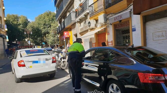 Un agente revisa la documentación de un conductor de VTC en la confluencia de las calles Águilas con Candilejo.