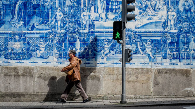Un hombre camina por una calle del centro de Oporto.