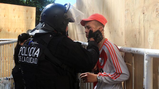 Un policía detiene a un aficionado de River Plate.