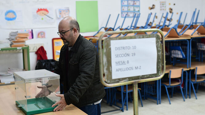 Un hombre coloca una urna en un colegio electoral de Córdoba.