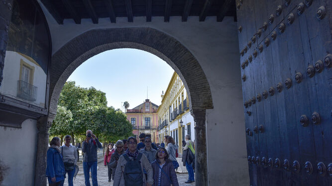 Turistas acceden al barrio de Santa Cruz desde el Patio de Banderas.
