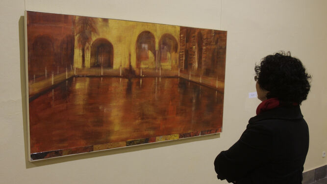 Una mujer contempla uno de los cuadros del pintor Paco Broca.