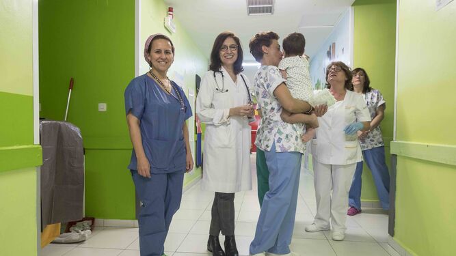 Las doctoras Rosa Romero y Ana Sánchez, junto a la enfermera Ana Alcocer, que sostiene en brazos a un pequeño afectado por enfermedad renal crónica..