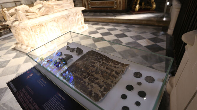Monedas y otros enseres que han sido hallados en el interior del sepulcro del arzobispo y que ahora se pueden contemplar en una vitrina en la Capilla de Santiago.