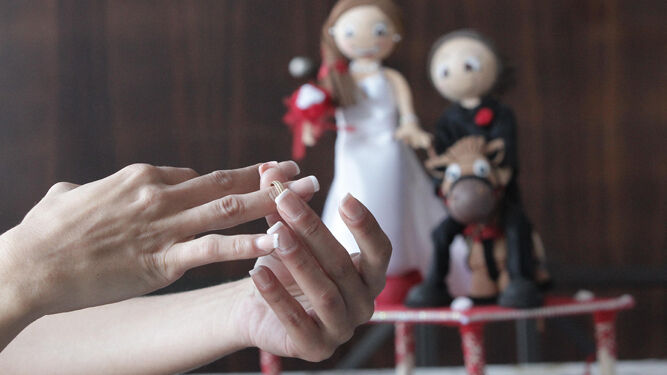 Unas manos de mujer se despojan de un anillo matrimonial.
