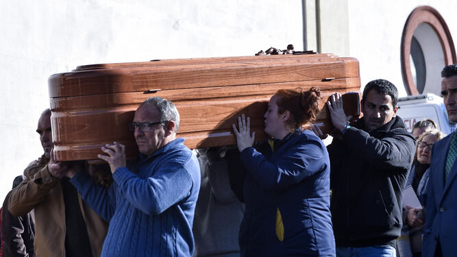 Una mujer besa uno de los ataúdes en el funeral de Las Cabezas de San Juan.