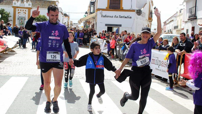 El pequeño Borja acompañado por sus padres, Borja y Ángeles, en la carrera benéfica que se celebra en La Puebla del Río.