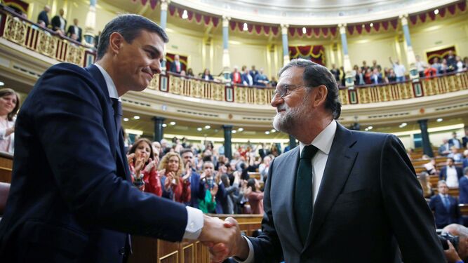 Sánchez y Rajoy se dan la mano tras prosperar la moción de censura.