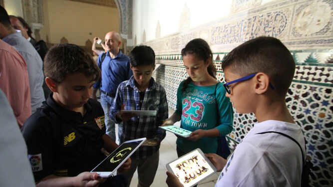 Niños con su tablet durante una visita guiada al Real Alcázar de Sevilla.
