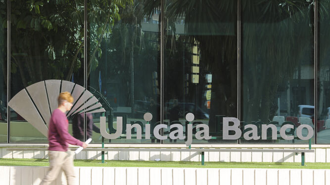 Un hombre pasa junto a la sede central de Unicaja Banco en Málaga