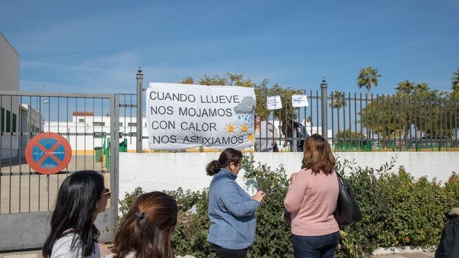 Un grupo de madres ante la pancarta y carteles que la AMPA ha colocado en el colegio Espartinas.