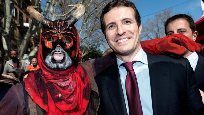 Pablo Casado, líder del PP, posa en Palma con una persona disfrazada de demonio.