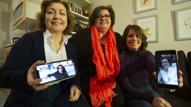 María del Carmen García Perea muestra la foto de su hija Carmen, residente en Dubái, junto a sus hermanas Rosa y Esperanza, que sostiene la foto de su madre, Carmen, ausente en la reunión familiar pero presente en todos los comentarios.