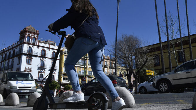 Una usuaria de un patinete eléctrico por el carril bici de la ciudad.