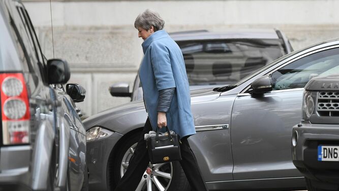 Theresa May camina hacia la entrada trasera de su residencia oficial en Downing Street.