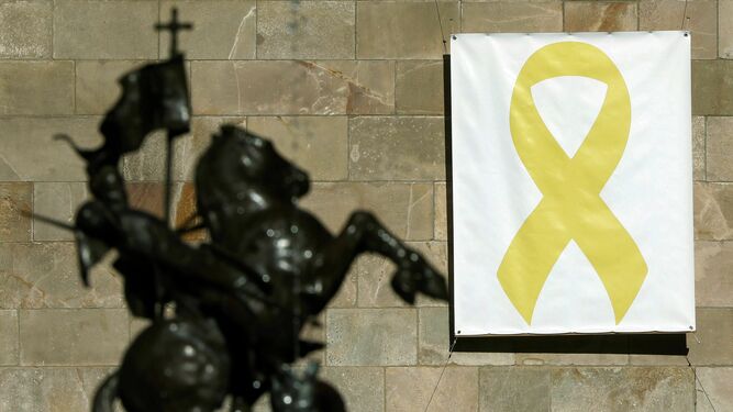 Vista de la pancarta con el lazo amarillo colgada en el Palau de la Generalitat.