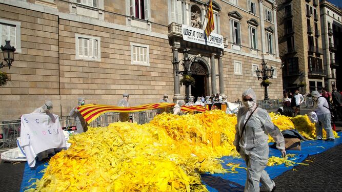 Antiindependentistas vuelcan sacos de lazos amarillos frente a la Generalitat