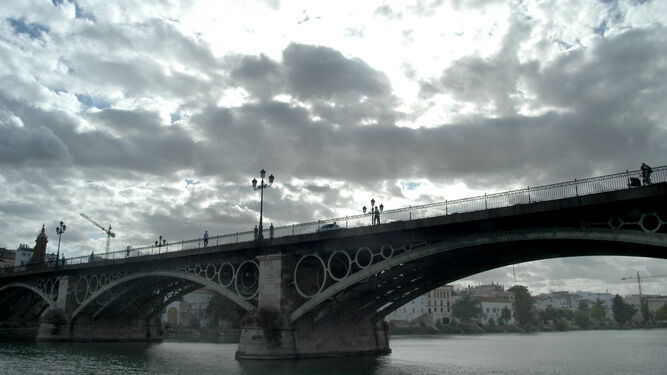 Vista de puente de Triana bajo el cielo nublado en Sevilla.