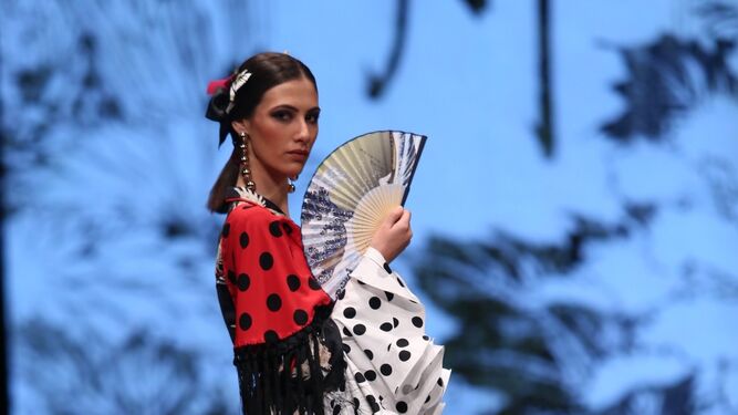 De alto contraste como esta propuesta de Yolanda Moda Flamenca en SIMOF 2019, que resalta el blanco nuclear del tejido del vestido con un animado mantoncillo rojo del lunares negros.&nbsp;Fotograf&iacute;a de Bel&eacute;n Vargas.
