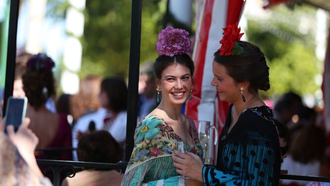 Dos flamencas charlan a las puertas de una caseta en la Feria de Abril de Sevilla.