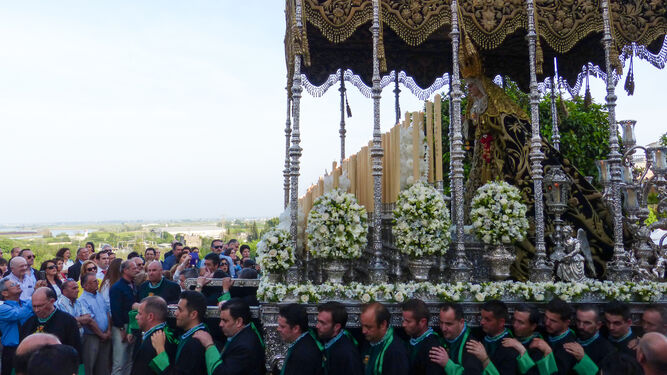 El portentoso paso de la Virgen de las Angustias Coronada es portado por nazarenos.
