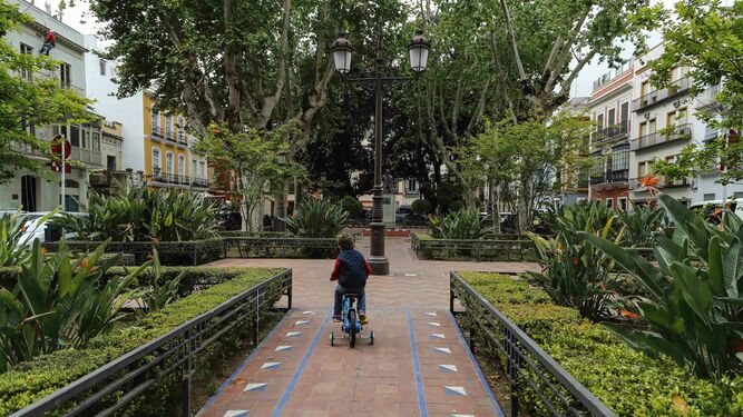 Un niño en bicicleta por el recuperado jardín de la plaza Cristo de Burgos.