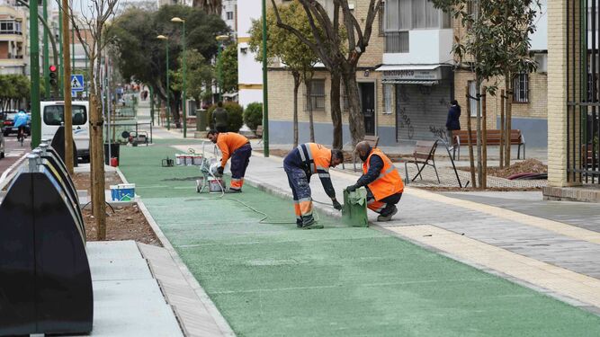 Varios operarios realizan tareas en el carril bici de la avenida del Greco el mismo día de la inauguración.