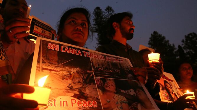 Miembros de varias ONGs sostienen velas en homenaje a las víctimas de los atentados del Domingo de Resurrección en Sri Lanka.