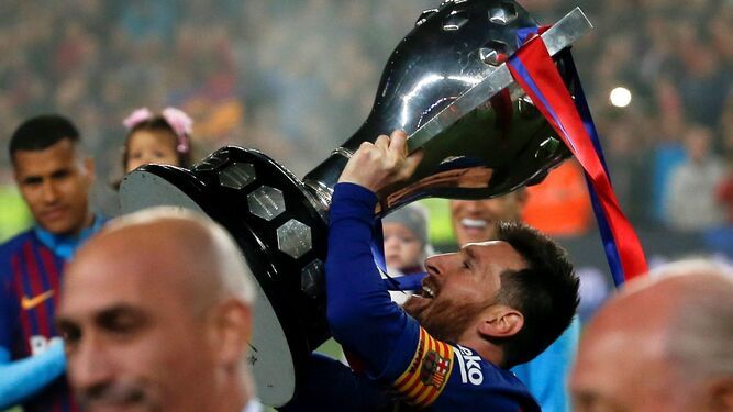 Messi levanta la copa de campeón de liga en el césped del Camp Nou entregada de manos de Luis Rubiales, presidente de la Real Federación Española de Fútbol.