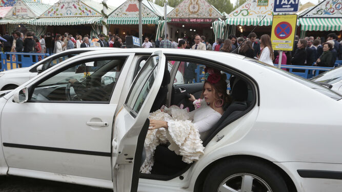 Una joven se baja de un coche en la Feria de Abril.