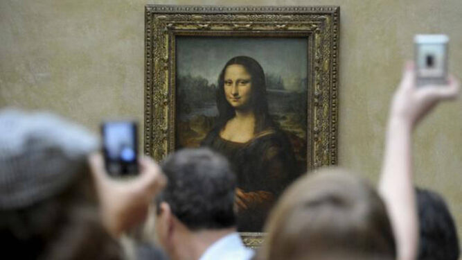 Visitantes en el Museo del Louvre de París fotografían el célebre cuadro de 'La Gioconda'.