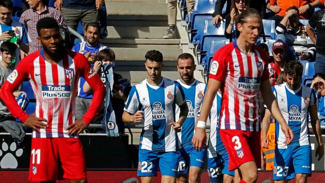Los jugadores del Espanyol celebran uno de los tantos ante los desolados Lemar y Filipe Luis.