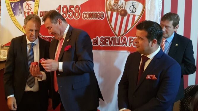Caparrós recibe el escudo de oro de Guillermo Jiménez junto a Carlos Jiménez.