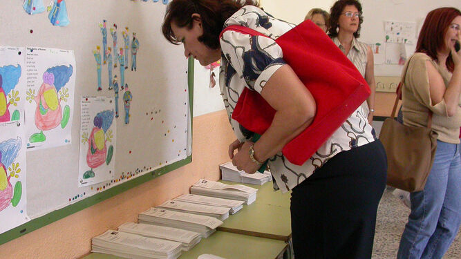 Una vecina de Dos Hermanas elige su papeleta en un colegio electoral en las elecciones municipales de 2015.