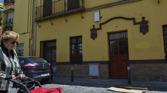 Una mujer pasa con un carro de la compra junto al edificio, enclavando en el número 16 de la calle Hiniesta.