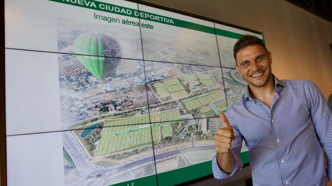 Joaquín posa con un plano de la nueva ciudad deportiva del Betis de fondo.
